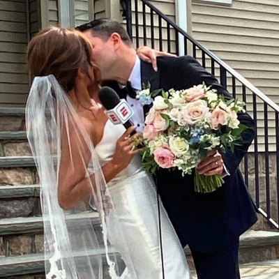 Dianna Russini held a ESPN mic while posing for a wedding picture.